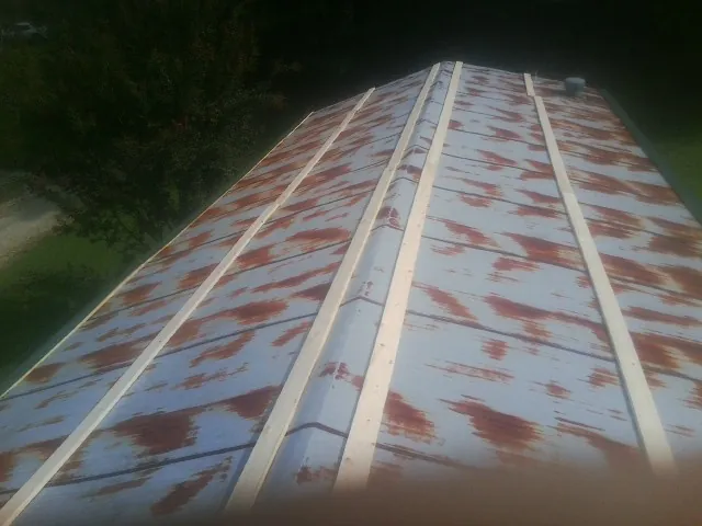 Rusted metal roof panels with new wood purlins before replacement — Storm Damage Roof Repair in Eckert by Roofing Brothers