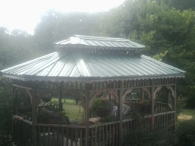 Two tier green metal roof on a garden gazebo in Eckert