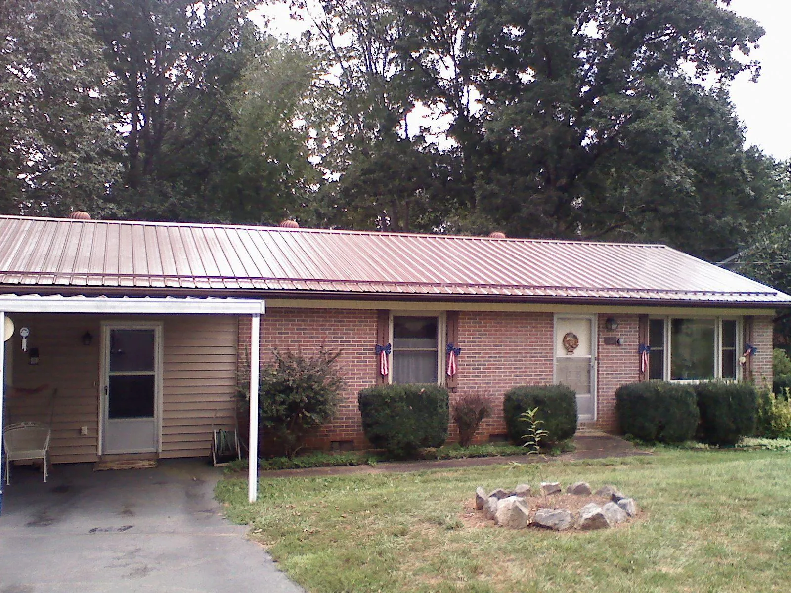 Bronze metal roof and carport on a brick ranch home — Roof Repair work by our crew in Eckert